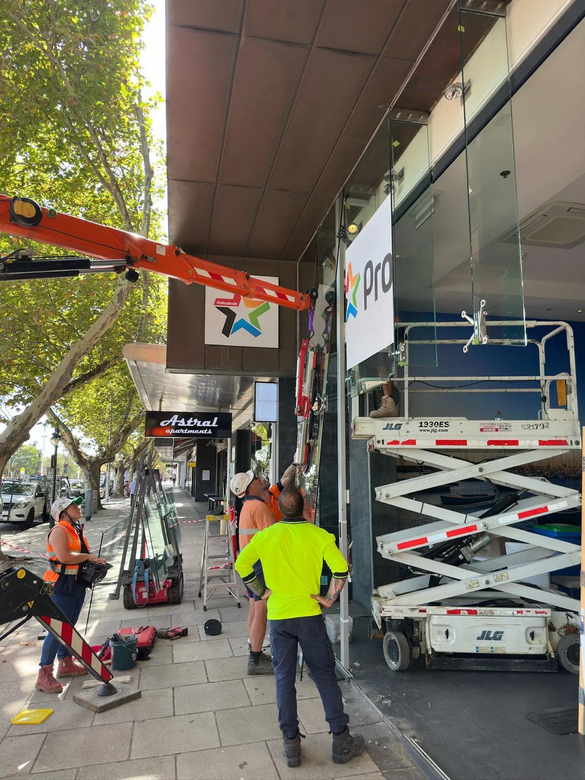 The Maison Glass team installing a glass façade panel on site